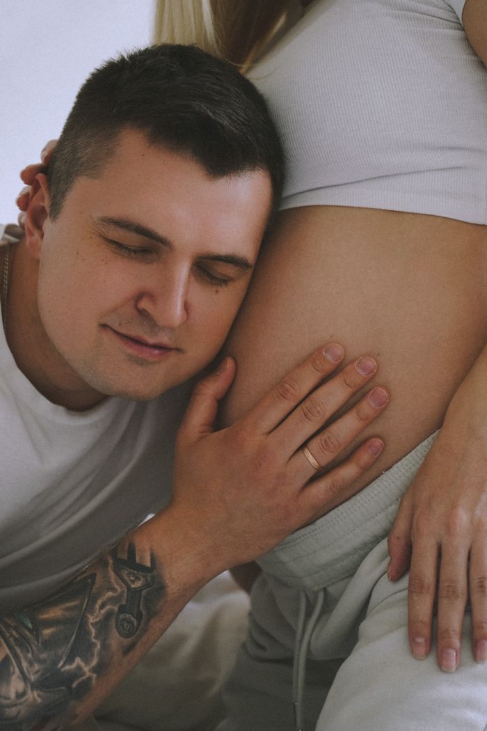 A heartwarming maternity photo featuring a father gently holding the pregnant belly of his partner.